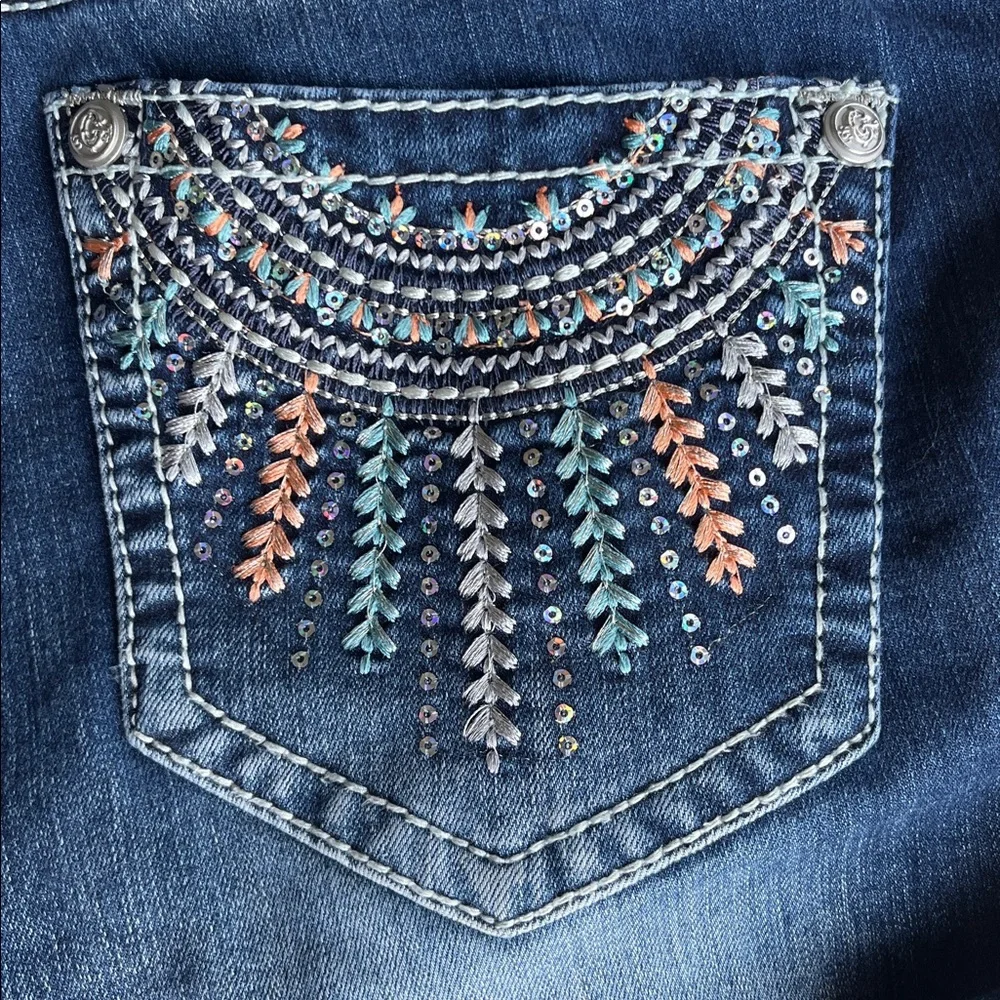 Grace in LA bootcut blue jeans with sequin and embroidery designs. Women’s 29